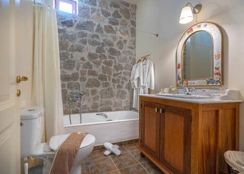 a bathroom with a sink and a tub and a toilet at Lavanda e Pietra in Lygourio