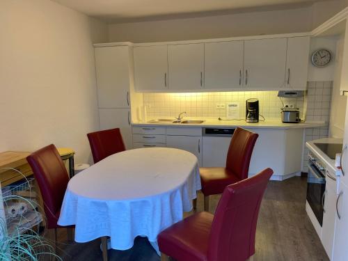 eine Küche mit einem weißen Tisch und Stühlen sowie einer Theke in der Unterkunft Haus Mühlenberg in Arnsberg