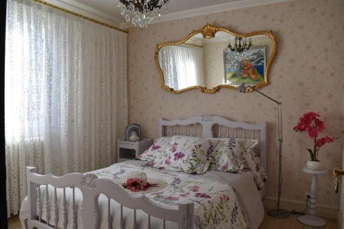 1 dormitorio con cama blanca y espejo en Gîte Au printemps Japonais, petit train de la Mure, parc des Ecrins, en Pierre-Châtel