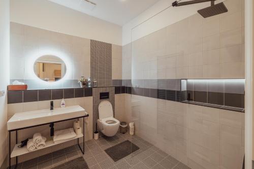 a bathroom with a toilet and a sink and a mirror at Apartmány Marienhof in Znojmo