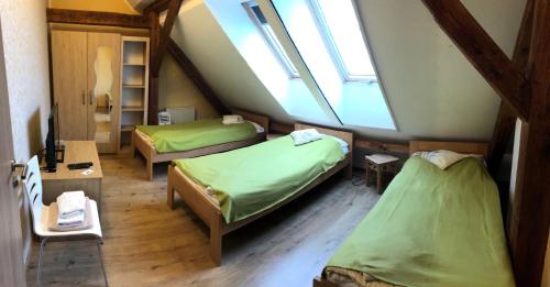 a attic room with two beds and a window at U Fousáče in Hrabětice