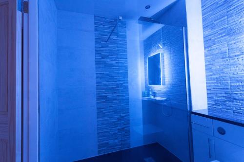 a bathroom with a glass shower with a sink at CITY CENTRE APARTMENT with Free Secure Underground Parking in Glasgow