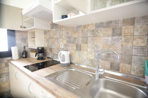 a kitchen with a sink and a counter top at Apartment Ljubica Tisno in Tisno