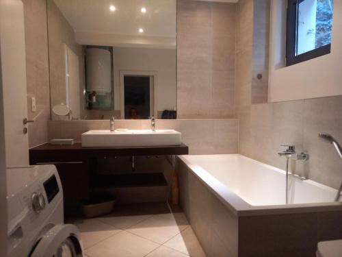 une salle de bain avec une baignoire, un lavabo et un miroir dans l'établissement Villa Malibu, à Mandelieu-la-Napoule