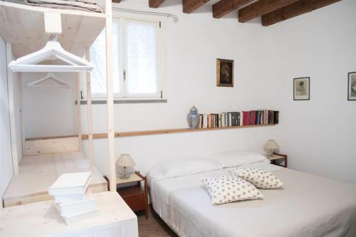 a white bedroom with two beds and a window at IseoLakeRental - Casa Rododendro in Sulzano