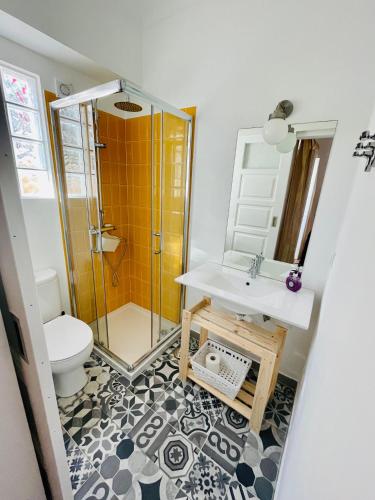 a bathroom with a shower and a sink and a toilet at Salty Home’s in Peniche