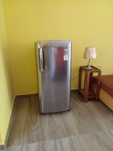 a refrigerator in a room with a lamp and a table at Sawanga Home Stay in Weligama