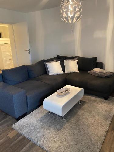 a living room with a blue couch and a white coffee table at Ferienwohnung am Tor zum Thüringer Wald in Plaue