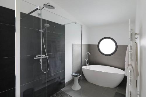 une salle de bain avec une baignoire et un miroir dans l'établissement La Belle Maison Patio, à Albi