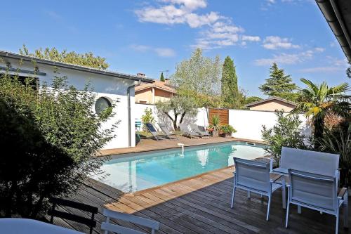 une cour arrière avec une piscine, une table et des chaises dans l'établissement La Belle Maison Patio, à Albi