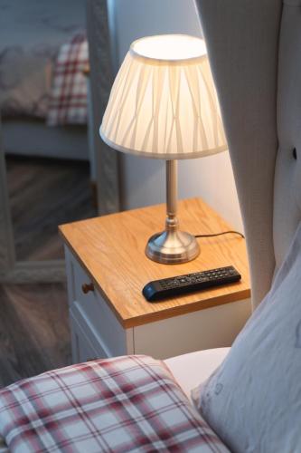 a lamp on a night stand next to a bed at CITY CENTRE APARTMENT with Free Secure Underground Parking in Glasgow