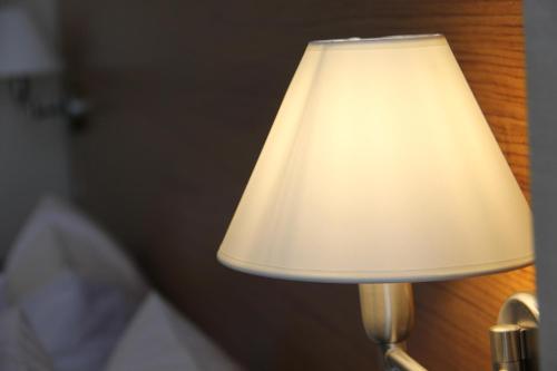 a lamp with a white shade on a wall at Khazar Inji in Baku