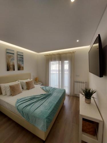 een slaapkamer met een bed en een tv aan de muur bij Beach Life Apartment, NEW, ELEGANT and COZY in Nazaré