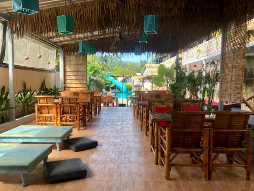 um restaurante com mesas e cadeiras de madeira e uma piscina em Samui Zenity em Mae Nam