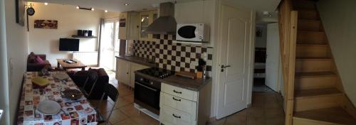 une cuisine avec une table et une cuisine avec un escalier dans l'établissement Osez la Creuse - Au bord du lac de Vassivière - 27, à Royère-de-Vassivière