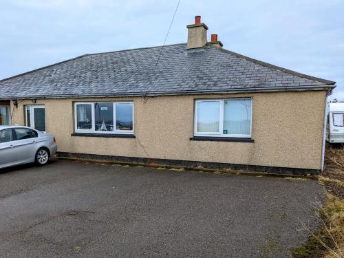 ジョン・オ・グローツにあるHamnavoe John o Groats Hostelの前に車が駐車されている家