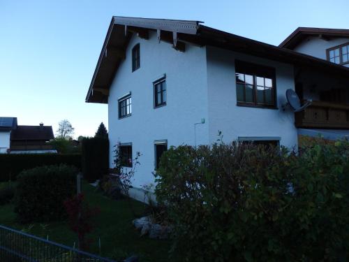 una casa blanca con ventanas y arbustos negros en Ferienwohnung Wiadahoam, en Marquartstein