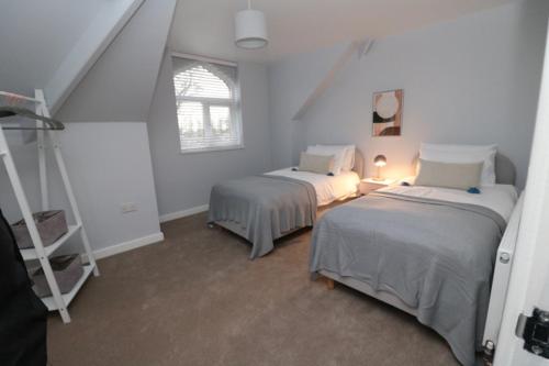Un dormitorio con 2 camas y una escalera. en The Snug en Stockton-on-Tees