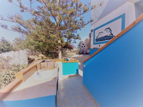 - un bâtiment bleu et blanc avec une table et des chaises dans l'établissement Case Pescatori, à Lampedusa
