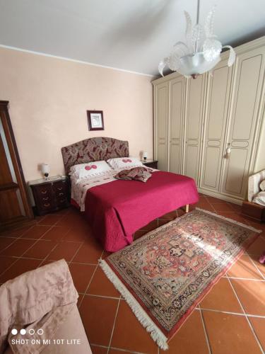 una camera con un letto con una coperta rosa e un tappeto di Villa Ida Bed & Breakfast a Terracina