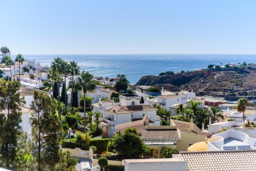 a view of a town with houses and the ocean at BnB Homes Ocean view Apartment with 3 spacious Terraces, 2 Swimming pools & Tennis court in Albufeira