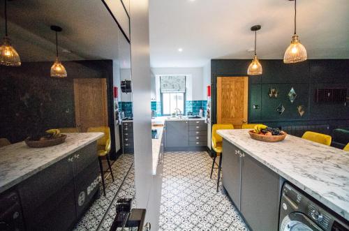 a kitchen with a counter top and a kitchen with yellow chairs at Wuthering Heights in Sedbergh