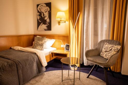 a hotel room with a bed and a chair at Hotel Restaurant Grüner Baum und Altes Tor in Bad Waldsee