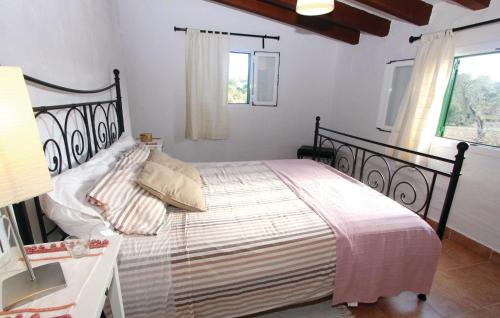 a bedroom with a bed and a table and a window at Nice Home In Algaida With 2 Bedrooms And Outdoor Swimming Pool in Algaida