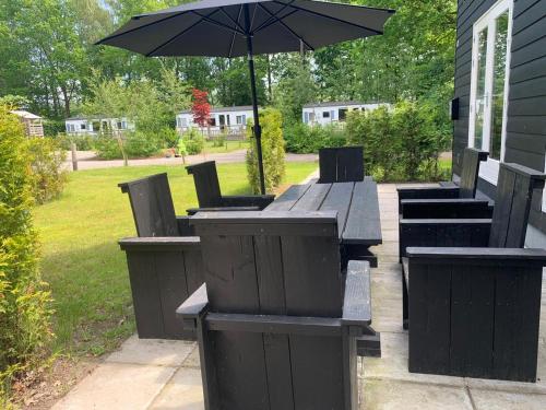 a picnic table with an umbrella in a yard at de4SeiZoentjes in Schoonebeek