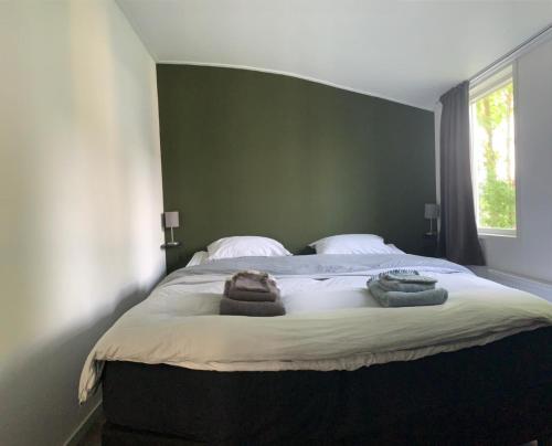 1 dormitorio con 1 cama grande y toallas. en de4SeiZoentjes en Schoonebeek
