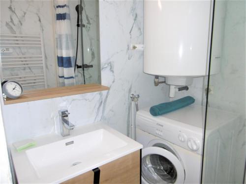 a bathroom with a sink and a washing machine at Appartement YOUN - à 500 m de la plage WIFI in Sarzeau