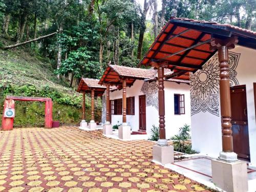 a house with a red roof and a brick driveway at STAYMAKER Qexperiences Coorg in Madikeri