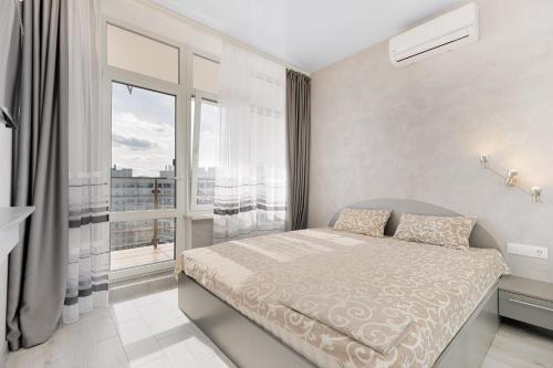 a bedroom with a bed and a large window at Pearl 44 Apartment With Terrace in Odesa