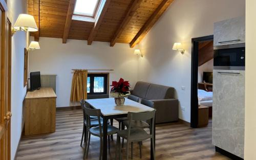 a living room with a table and chairs in a room at Antico Albergo Stella d'Italia in Folgaria