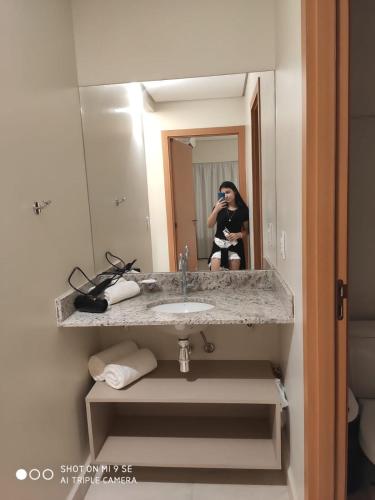 een vrouw die een foto van zichzelf neemt in een badkamerspiegel bij Salinas Park Resort Ap 506 para até 5 pessoas in Salinópolis