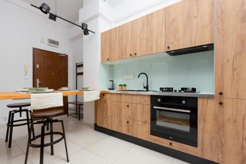 kuchnia z drewnianymi szafkami i kuchenką w obiekcie Praga Center Apartments by Renters w Warszawie