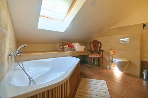 a bathroom with a bath tub and a skylight at Holiday Home Casa Buscina in Materada