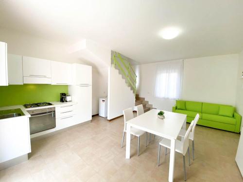 a kitchen with a white table and a green couch at Le Naiadi Appartamenti in Bolsena