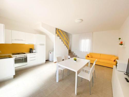 a kitchen and living room with a white table and chairs at Le Naiadi Appartamenti in Bolsena