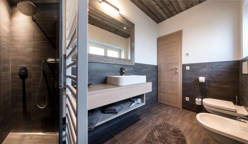 ein Bad mit einem Waschbecken und einem Spiegel in der Unterkunft Haus Wiesenstein in Lana