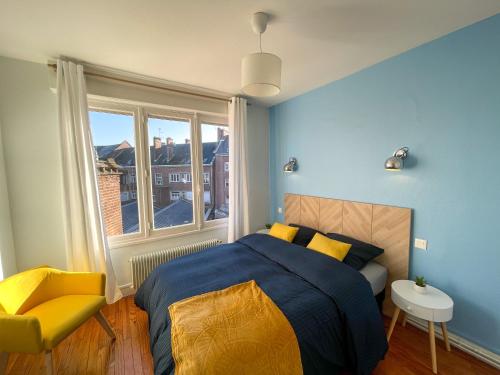 een slaapkamer met een bed, een gele stoel en een raam bij Cinéma & Disney avec Balcon & Parking en Hyper Centre in Amiens