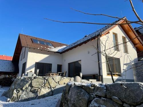 a house with a stone fence in front of it at Apartmán pri Dierach in Terchová
