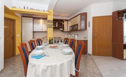 a dining room with a table and chairs in a kitchen at Apartment Brajki in Omiš