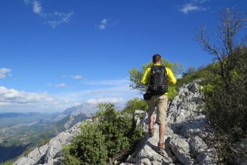 a man with a backpack standing on top of a mountain at Apartment Brajki in Omiš