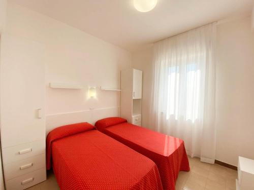 a bedroom with a red bed and a window at Le Naiadi Appartamenti in Bolsena
