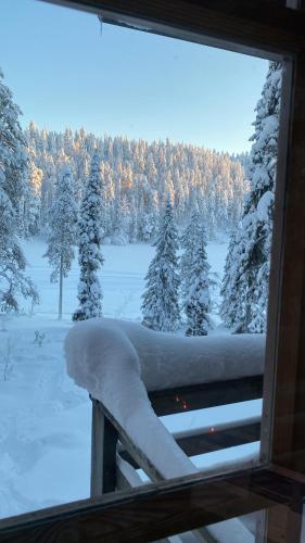 ein Fenster mit Blick auf ein schneebedecktes Feld mit Bäumen in der Unterkunft Holiday Home Ruka Lammensyli in Ruka