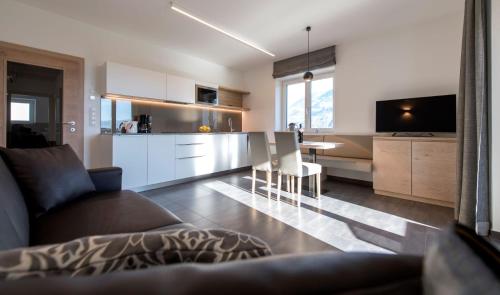 a kitchen and living room with a couch and a table at Haus Wiesenstein in Lana