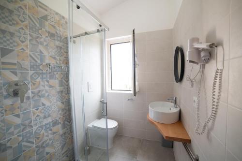 a bathroom with a toilet and a sink and a shower at B&B Belvedere in Ischitella