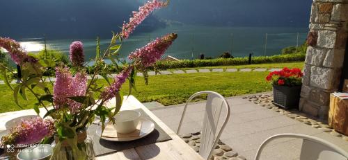 a table with a vase of purple flowers on it at Rocca d'Anfo B&B-Apartments Lake View in Rocca dʼAnfo