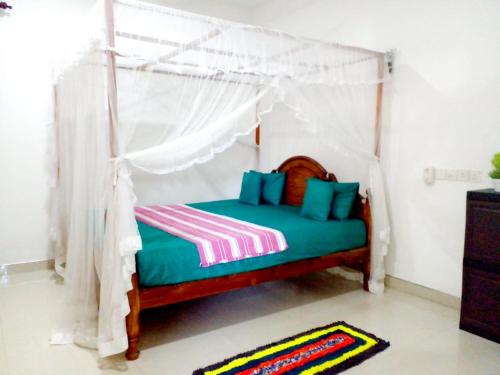 a bedroom with a bed with a canopy at Pradeep Guest House in Mirissa